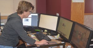 Angela Knuth working on computer with 4 monitors using software like Farmers Edge, CropZilla and Granular  