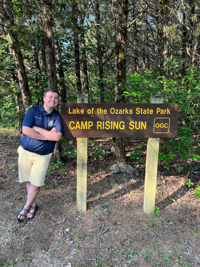 Courtesy of Grant Norfleet - Grant Norfleet posing next to a campground site sign
