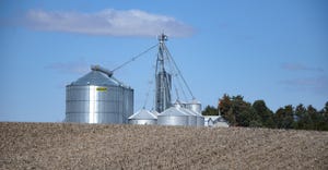 Panoramic view of grain bins across harvested fields