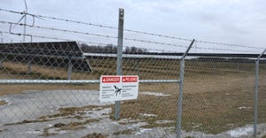 chain link fence around field of solar panels