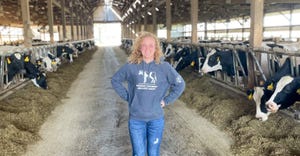 Paige Roberts standing in barn with dairy cows