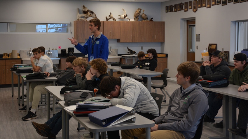 teacher standing among students at desks