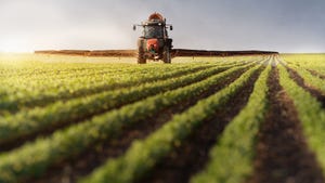 tractor spraying soybean field