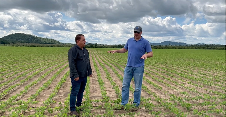 Kruse and a farmer standing in young soybean field Kruse and a farmer standing in young soybean field