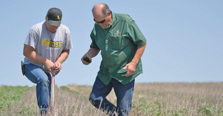Barry Ploog and Mike Beer observe soil and plant health