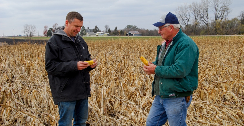 Bret Pierce and his father, Rod, shown inspecting a Boone County field damaged by the derecho