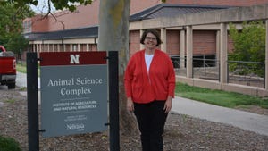 Dr. Deb VanOverbeke standing next to the UNL animal science sign