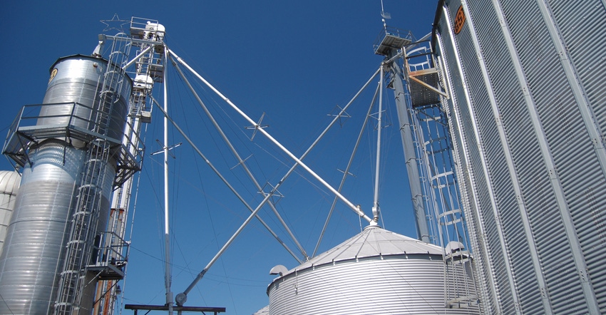 Upward view of grain bins against a blue sky