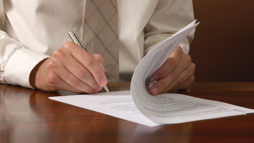 closeup of man's hands signing a document
