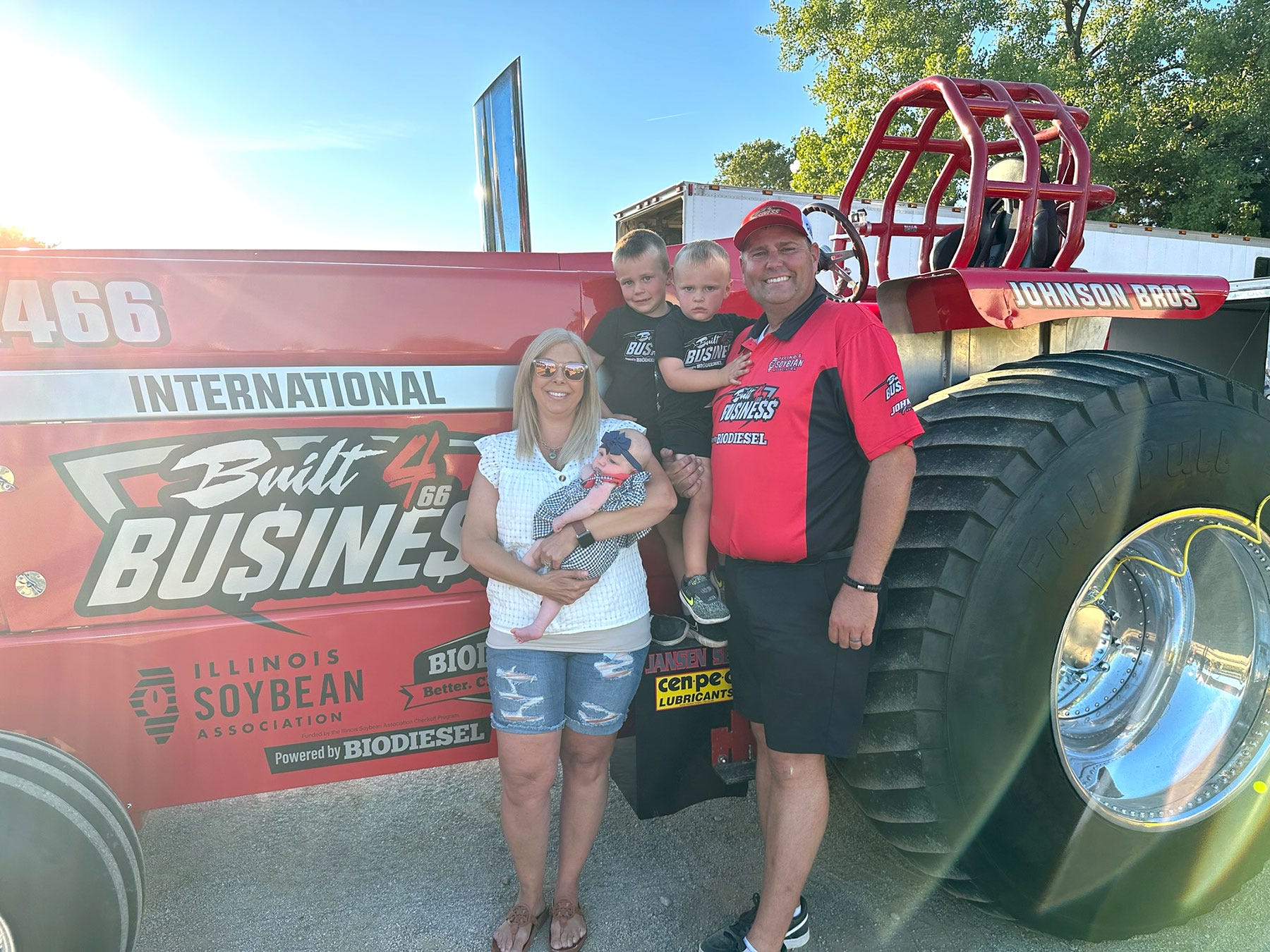 Anna, Kambryn, Kace, Beckett and KJ Johnson stand in front of their Built 4 Business International pulling tractor