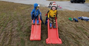 Mike and Sheilah Reskovac’s two boys play on plastic slides outside in their new yard
