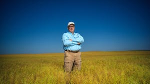 guy standing in field of camelina