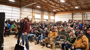 A large group gathered inside a workshop
