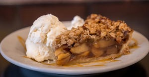 a warm slice of apple pie with a dollop of ice cream 