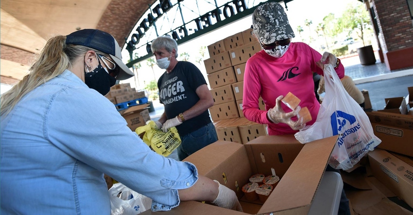 Volunteers wearing masks and gloves while preparing groceries at a food bank