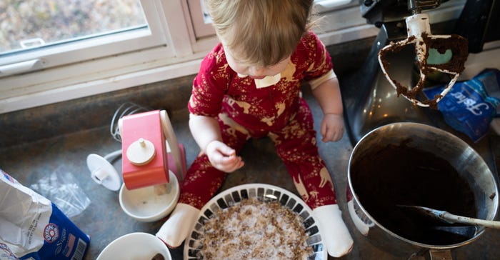 1-year-old Clare Haynes surrounded by baking dishes and ingredients