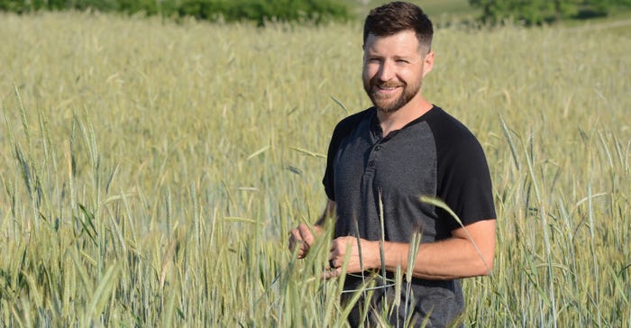 Jason Chatterton stands in field of cereal rye
