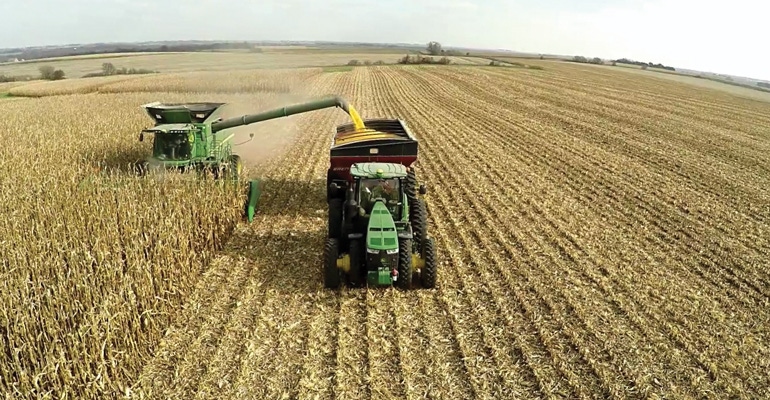 autonomous tractor offloading combine in field