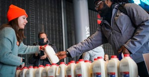 Woman handing a man a half gallon of milk