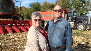 Rick and Connie Thompson standing in front of farm equipment