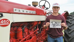  Tjerdan Johnson holds a picture of his great grandfather Lowell Wirtz with the same Farmall 460 tractor he is standing next to