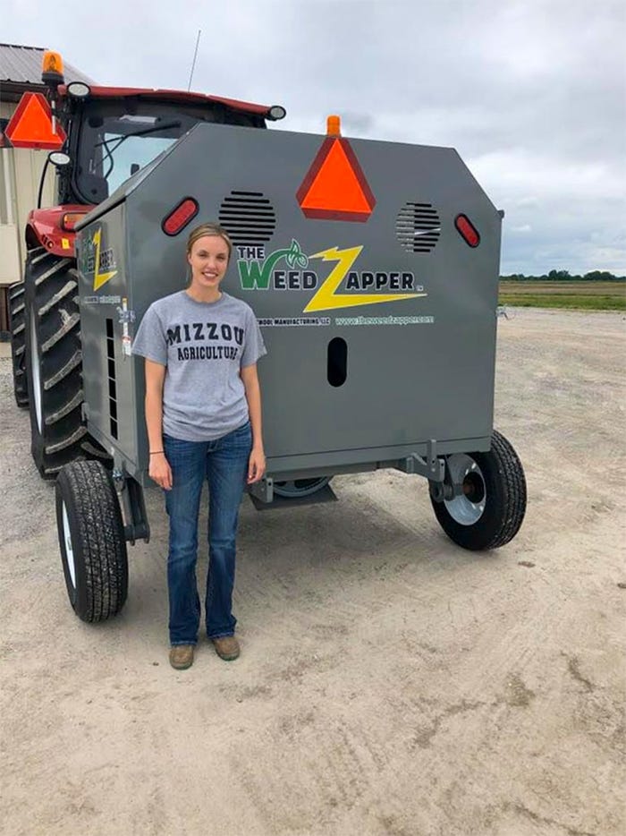 University of Missouri grad student, Haylee Schreier, standing in front of a weed zapper tractor