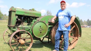 Ryan Stier standing with his steel-wheeled John Deere model D tractor