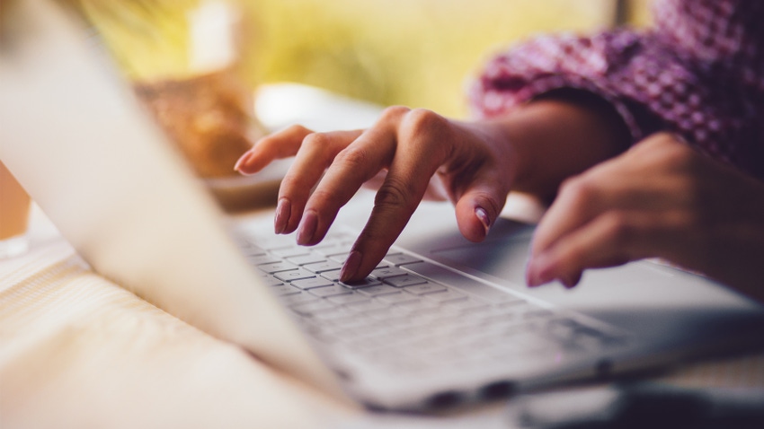 hands typing on laptop keyboard