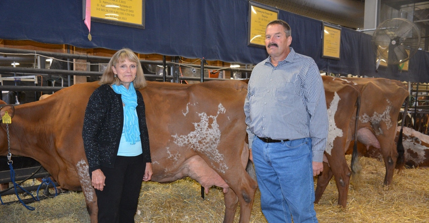 Ralph Shank and Mary Shank Creek, recipients of the Distinguished Breeder Award, stand beside Ayrshire breed