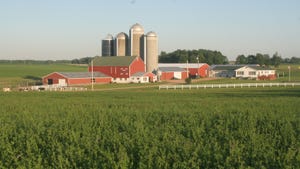 farmland with red barns and silos