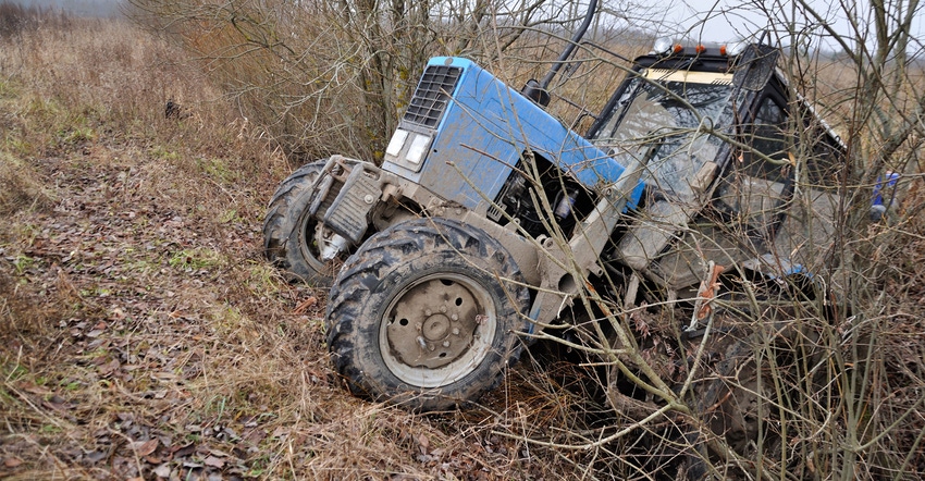 tractor in ditch in field with trees