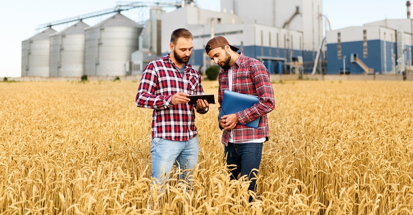 two young farmers standing in field two young farmers standing in field