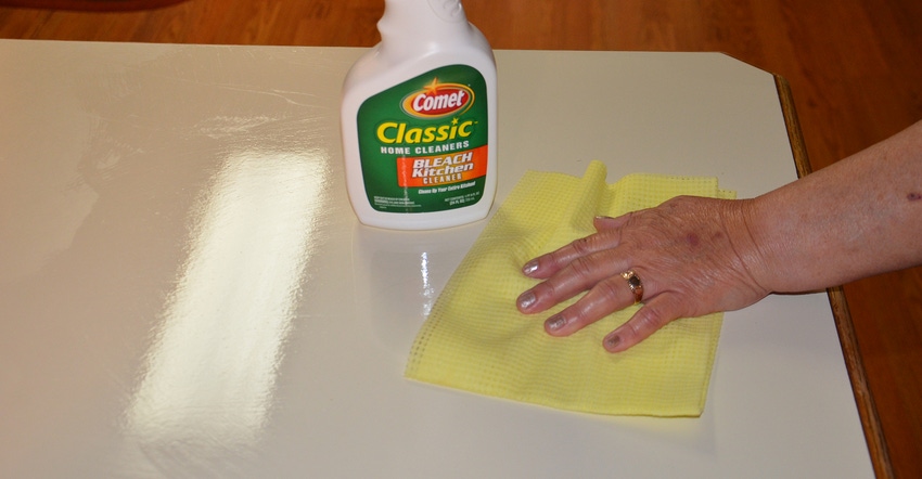 hand wiping down counter with cloth and clorox