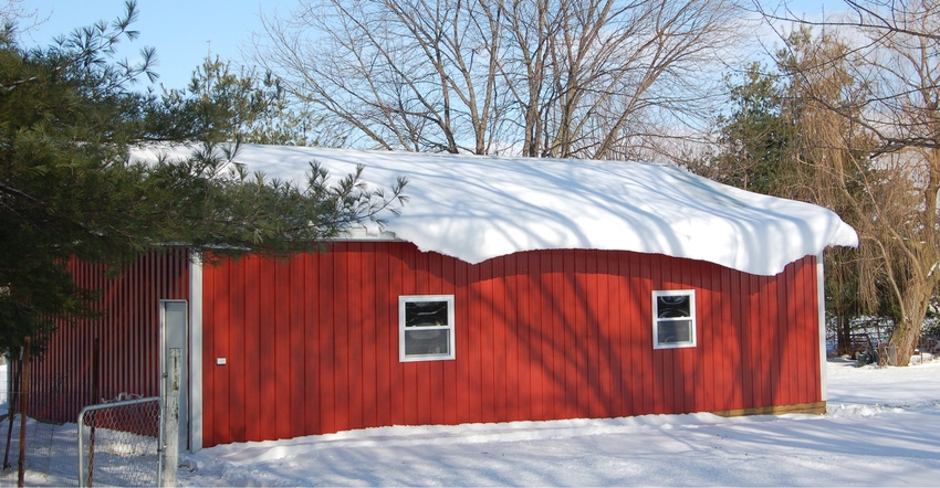 red pole barn covered in snow
