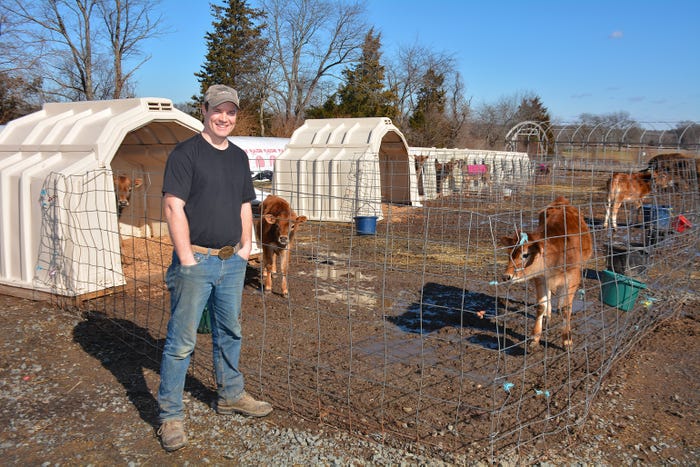 Dan Lyness stands with calves outside at Spring Run Dairy LLC