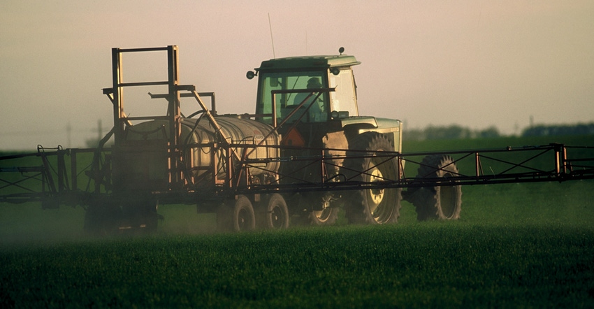 Tractor spraying herbicides on crops at dawn Tractor spraying herbicides on crops at dawn