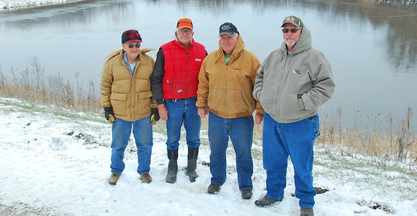 4 men at NRCS watershed project structure