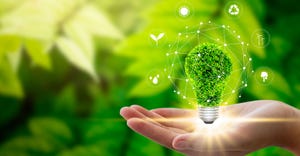 Hand holding light bulb against nature on green leaf with icons energy sources for renewable, sustainable development. Techno