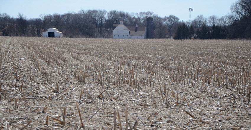 corn residue in field with barn in backgournd