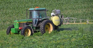 A tractor sprays pesticide to a field