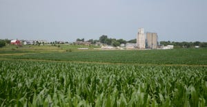 corn field with farm in background