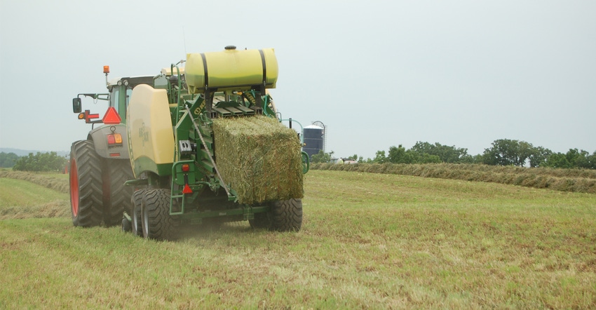 Tractor in field fertilizing pasture and hay ground 