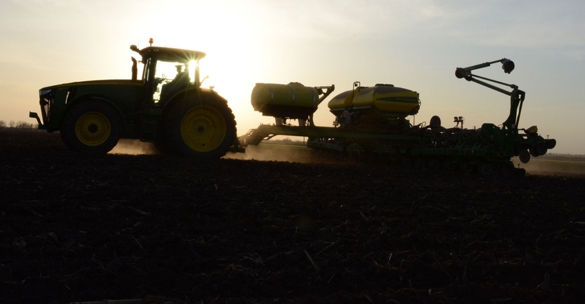 Silhouette of farm equipment in field