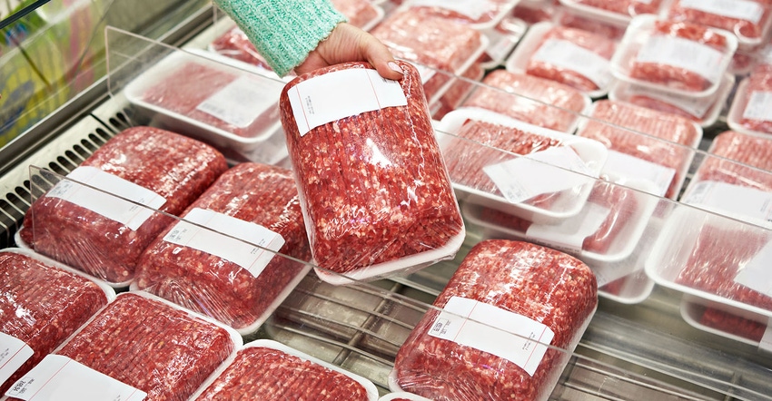 Woman chooses chopped meat in a shop