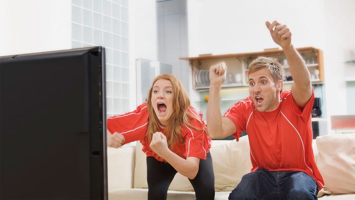 A couple watching a television and cheering