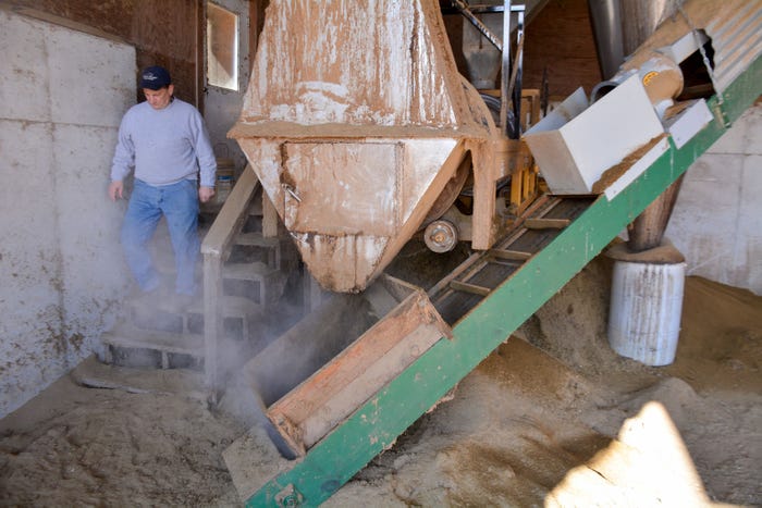 Reid looks on as a roaster attached to the manure separator heats up the dry manure