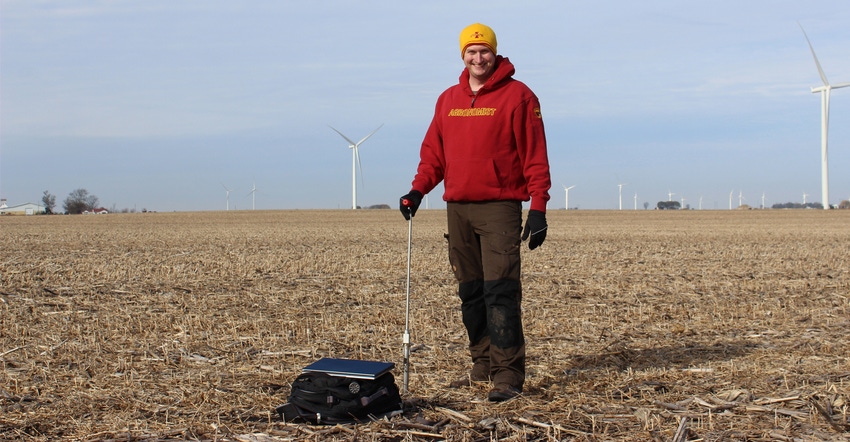 Bradley Miller takes soil samples from a field