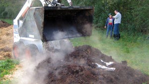 A loader moving a pile of manure