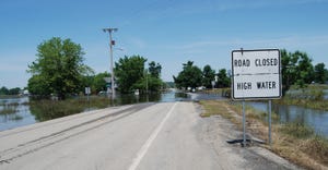 water over road with road closed high water sign