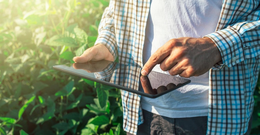 Close up of a farmer using a digital tablet in a crop field